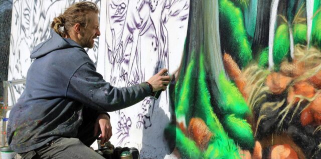 Martin Kremeň pri tvorbe graffiti steny