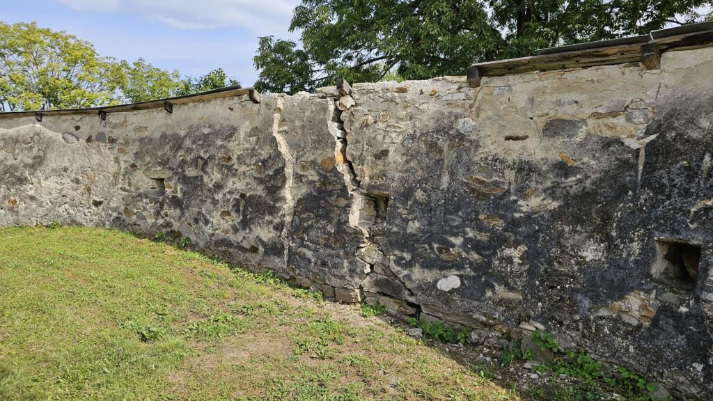 Renesančný múr kostola Rimavská Baňa s puklinami